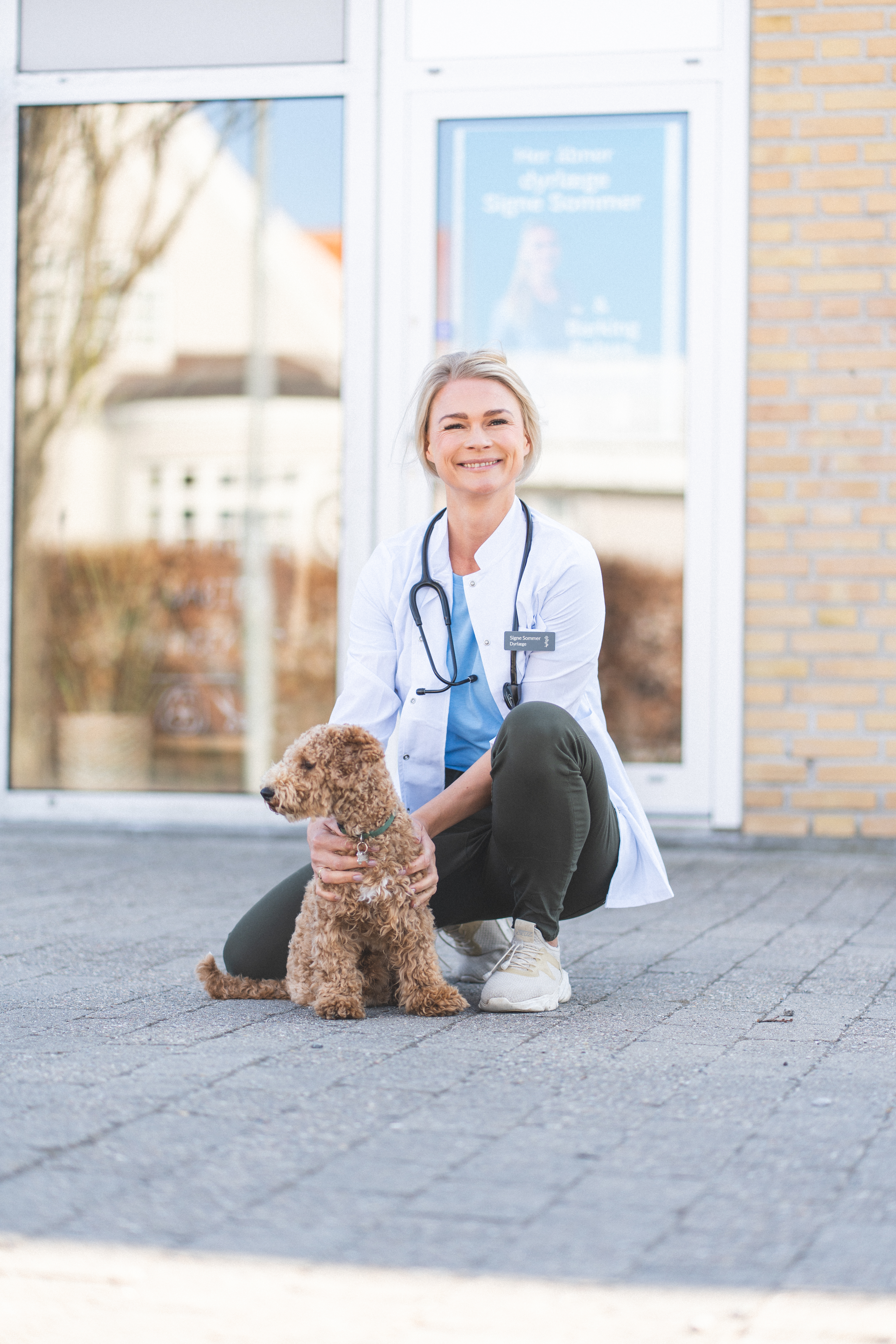 Signe foran klinikken med hund